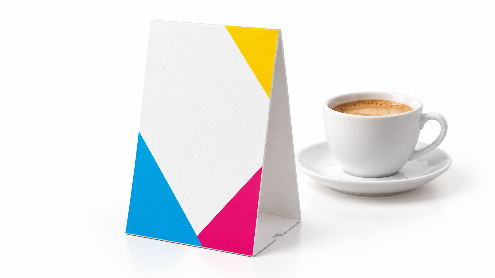 Tischaufsteller im CMYK-Design neben einer Kaffeetasse